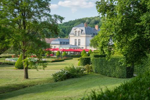 Courcelles-sur-Vesle科赛尔城堡酒店的公园里一座带围栏的大型白色房屋