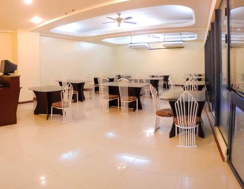 宿务曼达韦大都市花园酒店的一间带桌椅和天花板的用餐室