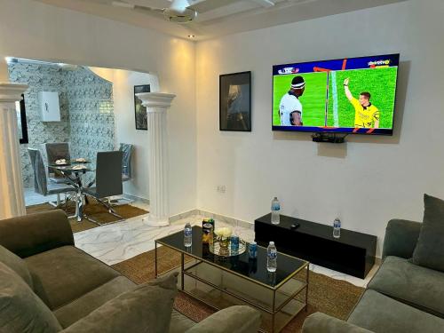 BrusubiThe Retreat Apartments的客厅配有沙发和墙上的电视