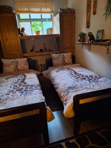 SteenbergenB&B de Vrijheid en de Ruimte in Steenbergen的一间卧室配有两张床和长颈鹿床单