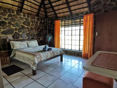 KareefonteinMoletani Game Ranch的一间卧室设有一张床和石墙