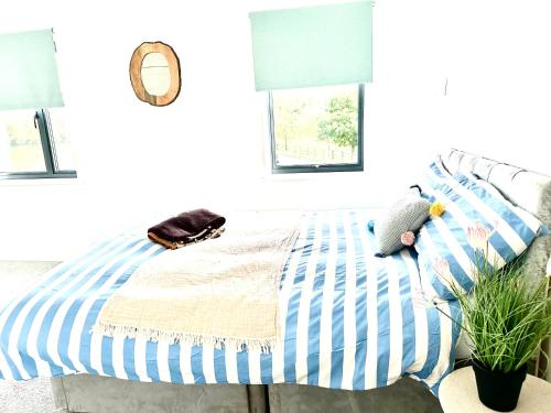 拉伊Rye Brand New Apartment的一间卧室配有一张蓝色和白色条纹的床