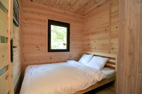 梅尔诺Bajkowy Las的小木屋内的一张床位,设有窗户