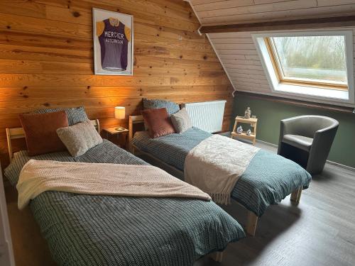 贝拉克尔't Coureurke的小木屋内一间卧室,配有两张床