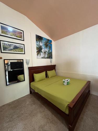 道伊斯Ice Bear Bar & Tourist Inn的一间卧室配有一张带绿色床单的床和一扇窗户。