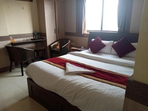 加德满都Hotel C O International的酒店客房配有一张带紫色枕头的大床