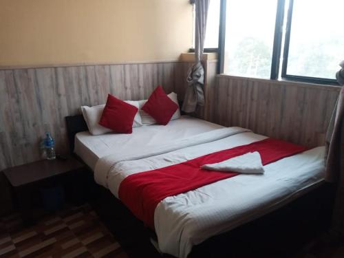 加德满都Hotel C O International的一张大床,配有红色和白色的床单和枕头