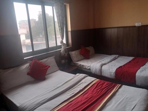 加德满都Hotel C O International的两张床位于带窗户的房间内