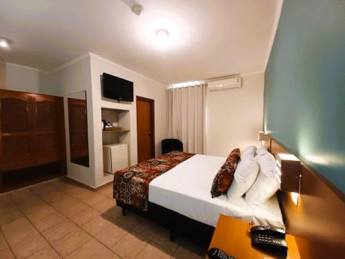 阿拉萨图巴里维埃拉酒店的配有一张床和一张书桌的酒店客房