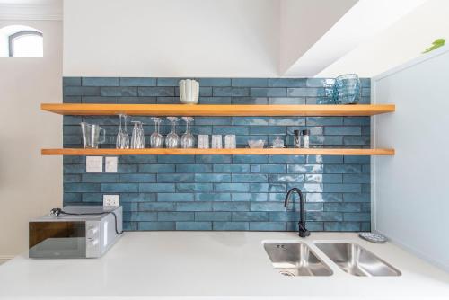 弗朗斯胡克Franschhoek Colours的厨房设有蓝色砖墙和木架