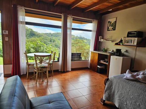 蒙泰韦尔德哥斯达黎加Apartment Monte Luna Mountain View的客房设有床、桌子和窗户。
