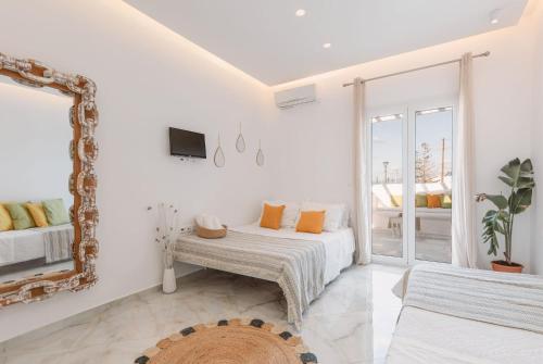 格拉斯托斯Dibellee Mykonos boutique studios的白色的客房配有床和镜子