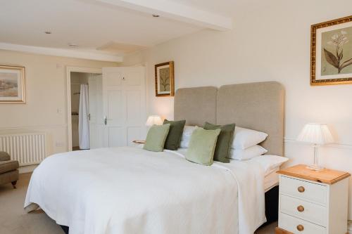 PrestonNightfold - 1 Bedroom Self-Catering Cottage的卧室配有带绿色枕头的大型白色床