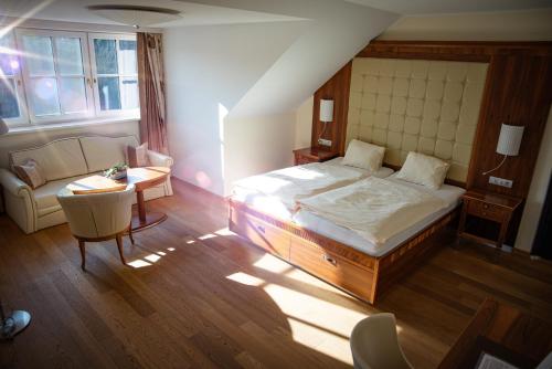 Ardagger StiftLandgasthof Winter的一间卧室配有一张床、一张沙发和一张桌子