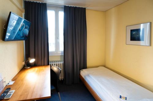 阿劳巴朗苏尔酒店的配有一张床、一张书桌和一扇窗户的酒店客房