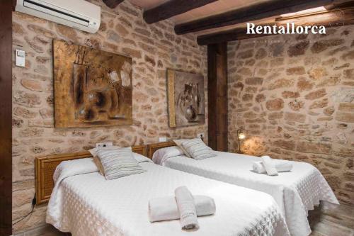 阿尔库迪亚Finca Comteses Petit by Rentallorca的石墙客房的两张床