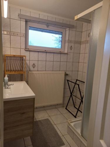 迪尔森-斯托科姆El Bosque的一间带水槽和浴缸的浴室以及窗户。