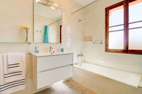 阿尔库迪亚Villa Can Siulet by Rentallorca的一间带水槽、浴缸和镜子的浴室