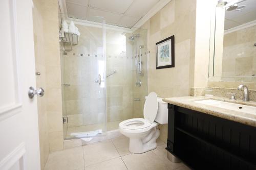 金斯敦考特利酒店及套房的浴室配有卫生间、淋浴和盥洗盆。