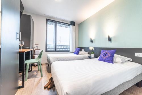 波尔多Montempô Bordeaux Centre - Bassins à flot的酒店客房配有两张床和一张桌子及椅子