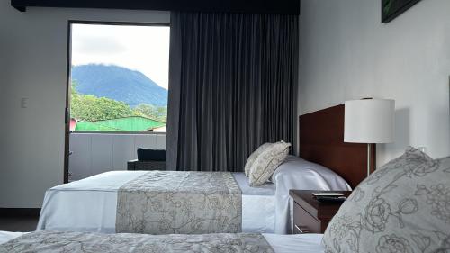 福尔图纳Arenal Monara的酒店客房设有两张床和窗户。