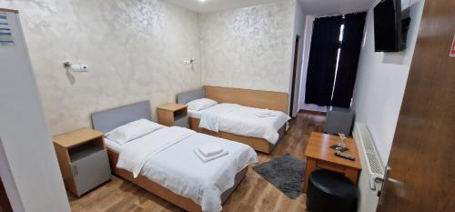 比斯特里察鹏西尼亚老警长汽车旅馆的客房设有两张床、一张桌子和一台电视。