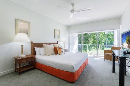 道格拉斯港Tropical Resort-style Living on Mirage Golf Course的一间卧室配有一张床、一张书桌和一个窗户。