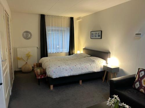 StevensweertVakantie Appartementen Engelen的一间卧室配有一张床和一张沙发