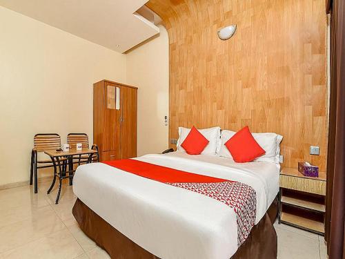 拉斯阿尔卡麦OYO Royal Plaza Residence -3的一间卧室配有一张带红色枕头的大床