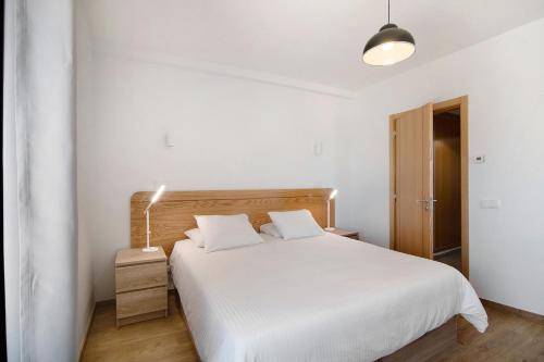 维拉诺瓦德卡塞拉Quinta da Bornacha - Casa A的卧室配有白色的床和灯