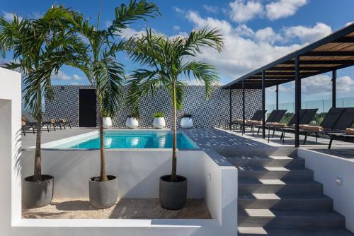 科苏梅尔Coralia Hotel Cozumel的一座游泳池,在大楼内种植了两棵棕榈树