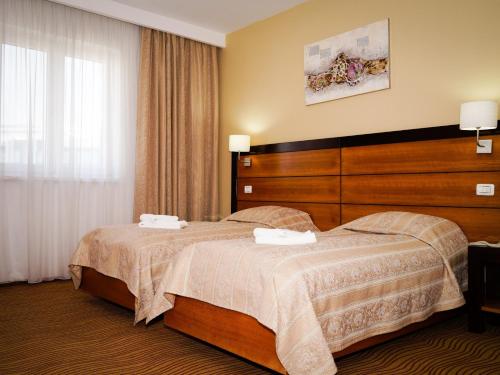 布加勒斯特HOTEL CRISS的酒店客房,配有床和梳妆台