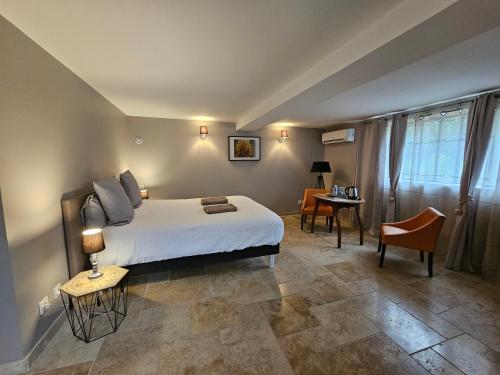 Rochefort-en-Valdaine摇滚乐旅馆的卧室配有1张床、1张桌子和1把椅子