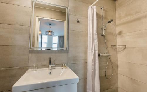 鹿特丹俄里翁酒店的浴室配有盥洗盆和带镜子的淋浴