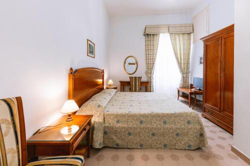 拉维罗托罗酒店的一间卧室配有一张床、梳妆台和桌子