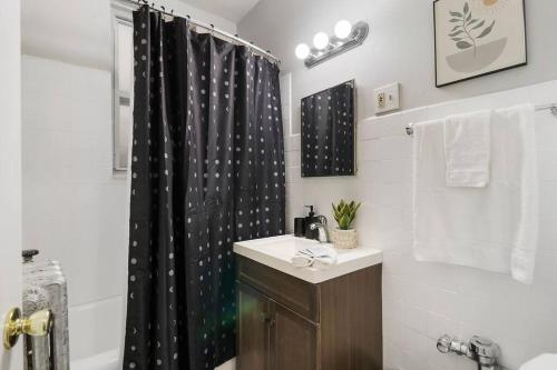 芝加哥Trendy Studio Apartment in Chicago - Kenwood 103 & 303 rep的浴室设有黑色淋浴帘和水槽