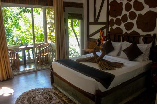 康提Villa Olde Ceylon的带阳台的客房里设有一间带一张床的卧室