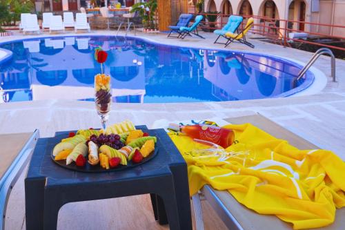 博德鲁姆Oscar Seaside Hotel & Spa的游泳池畔桌子上的一盘水果