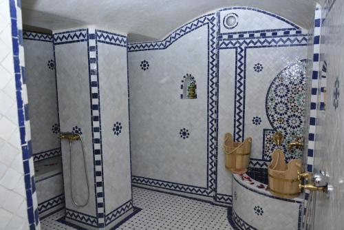 非斯Riad Fes Colors & Spa的浴室设有蓝色和白色瓷砖淋浴。