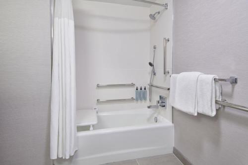 罗缪勒斯底特律都会机场罗穆卢斯万怡酒店的浴室配有浴缸、淋浴和毛巾。