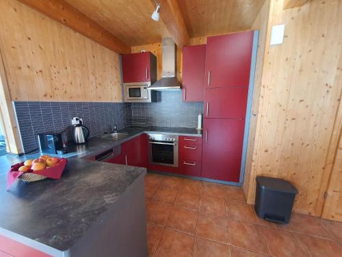 上陶恩Exclusive chalet in Hohentauern in ski area的一间厨房,配有红色橱柜和台面