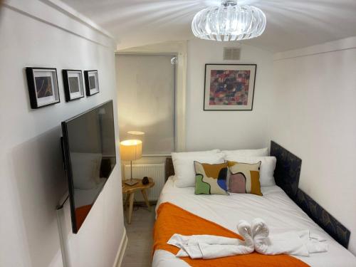 伦敦Central Point apartment的一间卧室配有一张带橙色毯子的床