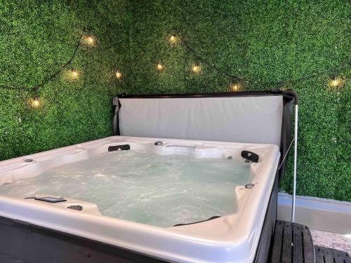 特拉弗斯城Upscale Urban Oasis: Spacious & Chic with Hot Tub!的浴缸配有带灯的绿色墙壁