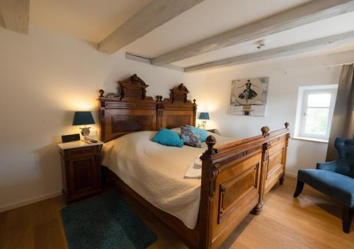 阿本贝格阿本贝格酒店的一间卧室配有一张大床和一张蓝色椅子