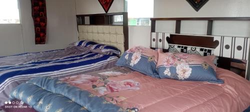 普诺casa ecológica的一间卧室配有两张带粉红色和蓝色枕头的床
