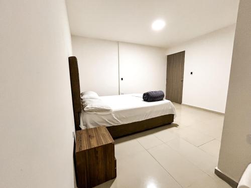 卡塔赫纳Hotel y Restaurante Oasis CTG的一间带床和木凳的小卧室