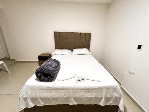 卡塔赫纳Hotel y Restaurante Oasis CTG的卧室配有一张白色大床,上面装有黑袋