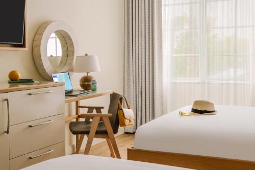 迈阿密海滩Sonder The Abbey的一间卧室配有一张床和一张带帽子的书桌