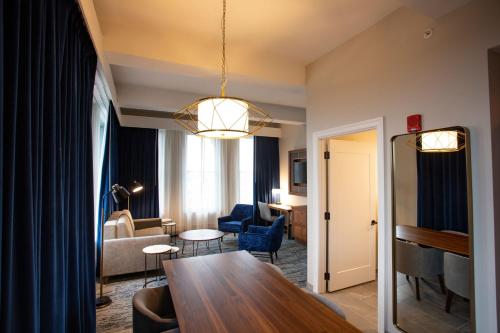 亚克朗BLU-Tique, Akron, a Tribute Portfolio Hotel的一间带桌子的客厅和一间带沙发的客厅