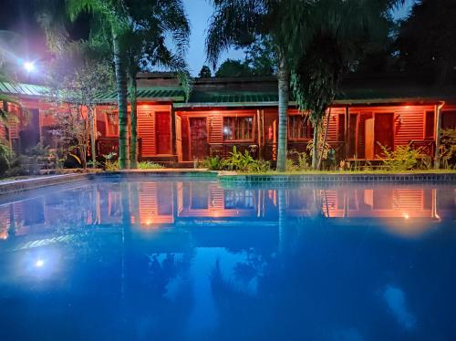 伊瓜苏港波萨达21号橙子酒店的夜间在房子前面的游泳池